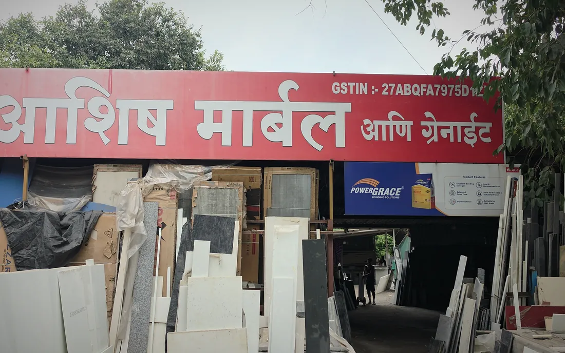 The shopfront of Ashish Marble and Granite on Tata Power Road, Khambalpada, with slabs stacked outside.